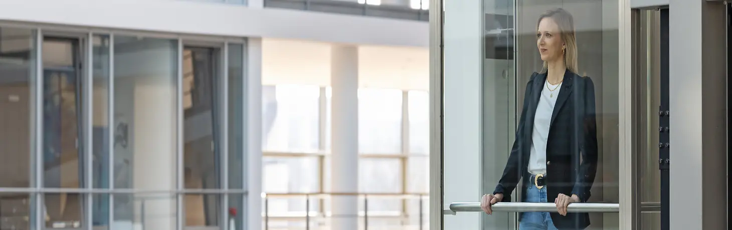 Une femme à la recherche de la façade en verre d'un immeuble de bureaux