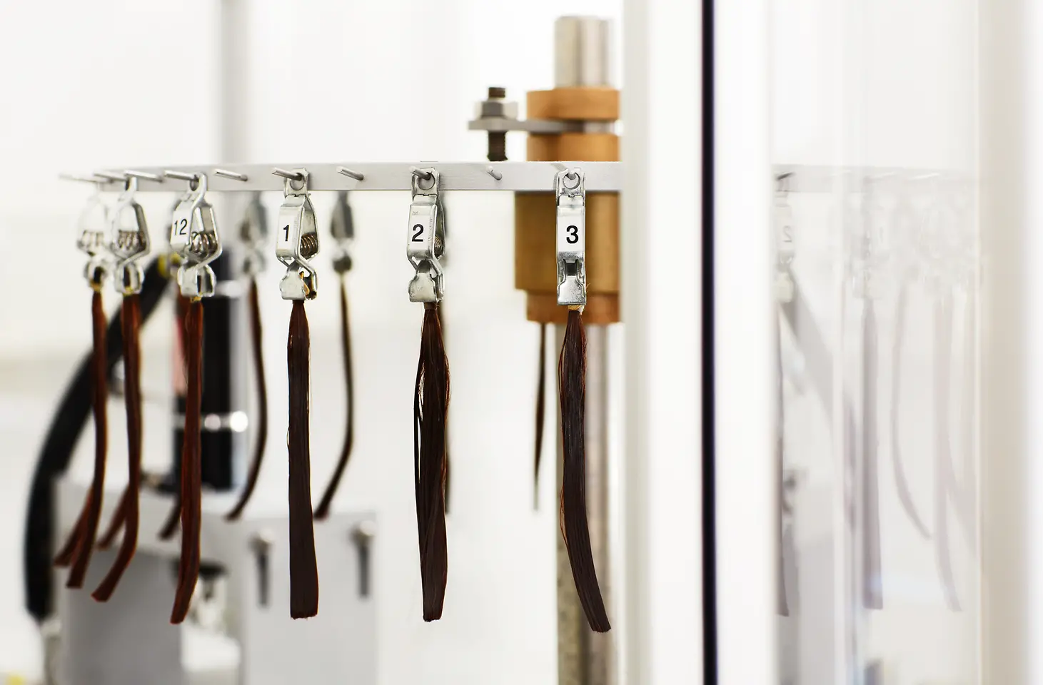 Brunette strands of hair are lined up on a hair robot.