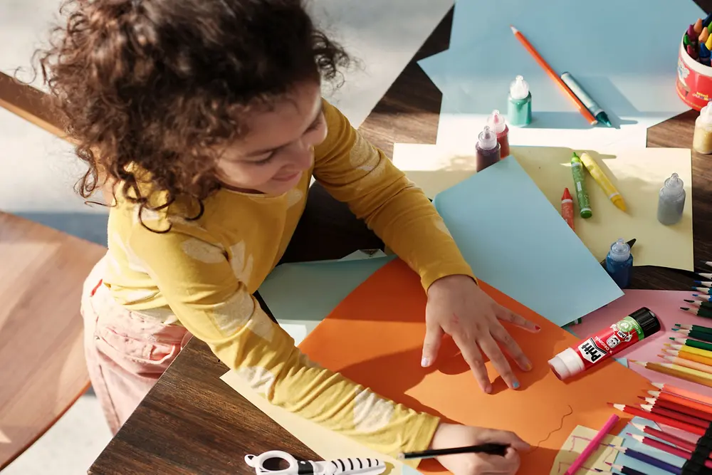 Child doing handicrafts using Pritt glue-stick